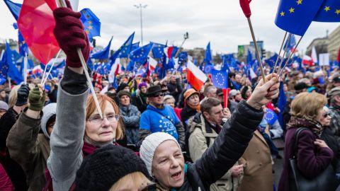 People wave EU and Polish flags Saturday in Warsaw on the 60th anniversary of the Treaty of Rome.