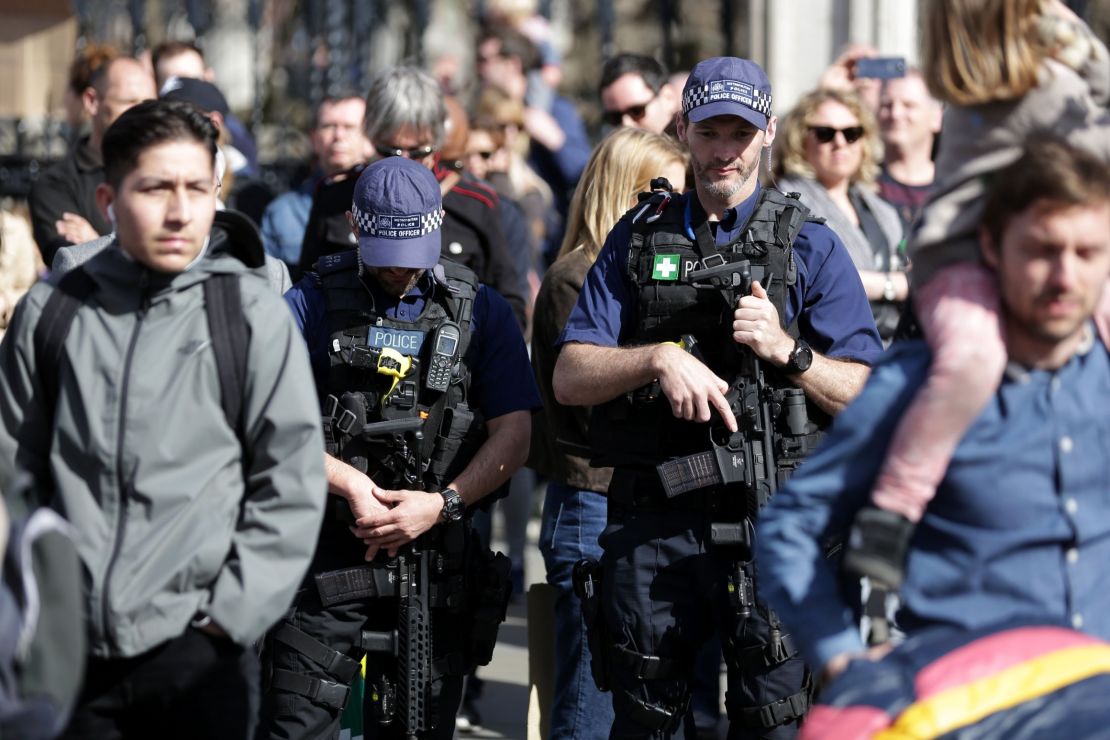 Armed British police officers carry their weapons as they patrol during Saturday's march.