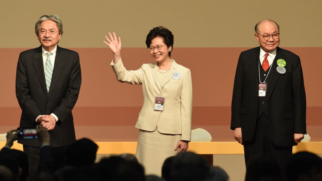 CORRECTION - Hong Kong's new chief executive Carrie Lam (C) waves while her defeated opponents Woo Kwok-hing (R) and John Tsang (L) look on after winning the Hong Kong chief executive election in Hong Kong on March 26, 2017.
Beijing favourite Carrie Lam was selected as Hong Kong's new leader by a mainly pro-China committee, in an election dismissed as a sham by democracy activists who fear the loss of the city's cherished freedoms. / AFP PHOTO / Anthony WALLACE / The erroneous mention[s] appearing in the metadata of this photo by Anthony WALLACE has been modified in AFP systems in the following manner: [correcting positioning of John Tsang and Woo Kwok-hing]. Please immediately remove the erroneous mention[s] from all your online services and delete it (them) from your servers. If you have been authorized by AFP to distribute it (them) to third parties, please ensure that the same actions are carried out by them. Failure to promptly comply with these instructions will entail liability on your part for any continued or post notification usage. Therefore we thank you very much for all your attention and prompt action. We are sorry for the inconvenience this notification may cause and remain at your disposal for any further information you may require.        (Photo credit should read ANTHONY WALLACE/AFP/Getty Images)