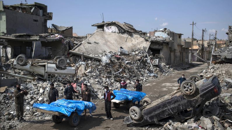 Residents carry the bodies of people killed during skirmishes between Iraq security forces and ISIS on the western side of Mosul on Friday, March 24, 2017. Residents of the al Jadidah neighborhood say scores of civilians are believed to have been killed by airstrikes that hit a cluster of homes in the area earlier this month.