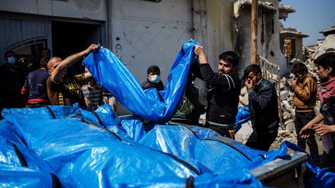 Residents pile body bags into the back of a pickup truck after recovering them from the rubble in the al Jadidah neighborhood of Mosul.