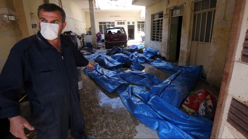 An Iraqi rescue worker gestures towards bodies wrapped in plastic in the al Jadidah area on March 26, 2017, following airstrikes in which civilians were reportedly killed.  