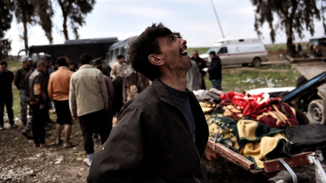 A man mourns near the bodies of Iraqi residents killed in a March 17 airstrike in Mosul. 