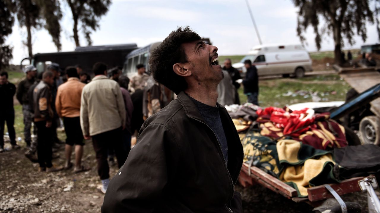 A man mourns near the bodies of Iraqi residents killed in a March 17 airstrike in Mosul.