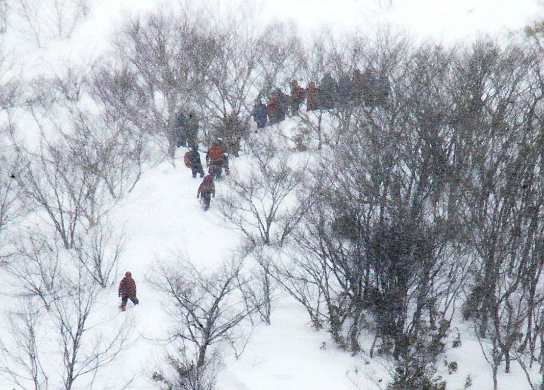 Rescue team members climb the mountain at Nasu Onsen Family Ski Resort.