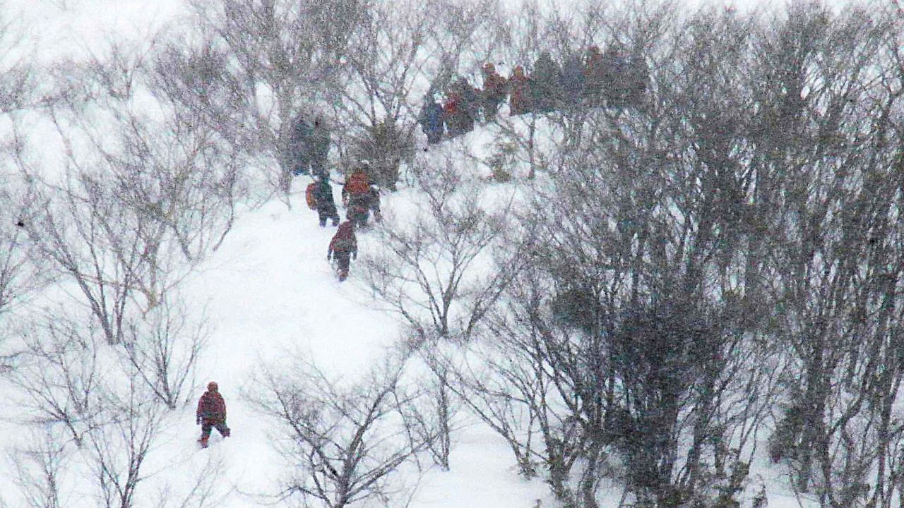 Rescue team members climb the mountain at Nasu Onsen Family Ski Resort.