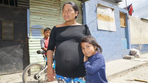 Angelina, a pregnant mother of three, and her youngest daughter, Charon, outside their home in Guatemala City.