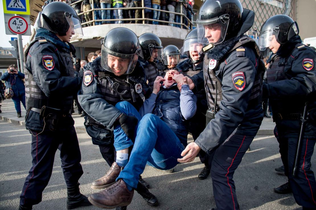 Riot police officers detain a protester during the rally in Moscow.
