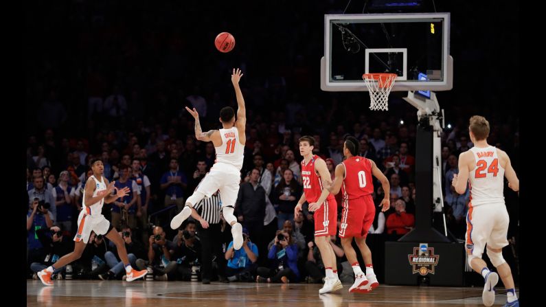 Florida guard Chris Chiozza, No. 11, puts up a last-second three-point shot to <a href="index.php?page=&url=http%3A%2F%2Fbleacherreport.com%2Farticles%2F2699941-florida-takes-the-win-vs-wisconsin-with" target="_blank" target="_blank">score the game-winning points</a> against Wisconsin in overtime of an NCAA East Regional semifinal game, Saturday, March 25. Florida won 84-83. 