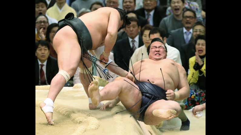 Japanese sumo wrestler Kisenosato is is thrown out of the ring by Harumafuji of Mongolia at the Spring Grand Sumo Tournament in Osaka, Japan, on Friday, March 24. 
