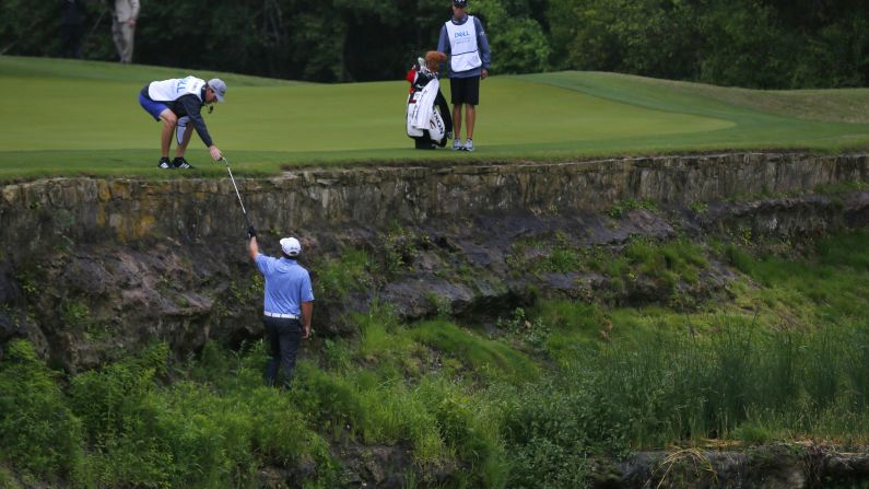 American golfer J.B. Holmes hands his club to his caddie on the third hole during round three of the World Golf Championships at Austin Country Club on Friday, March 24. 