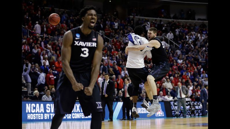 Xavier players Quentin Goodin, left, and Sean O'Mara, far right, celebrate after beating Arizona during an NCAA Tournament regional semifinal game Thursday, March 23. Gonzaga defeated Xavier on Saturday, March 25.