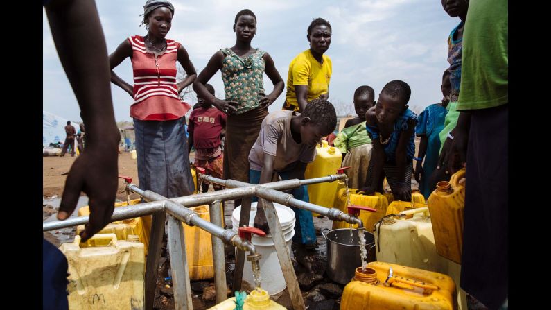 South Sudanese refugees fill jerrycans and other containers with water at the Imvepi Reception Centre, Arua District, Northern Region, Uganda.
