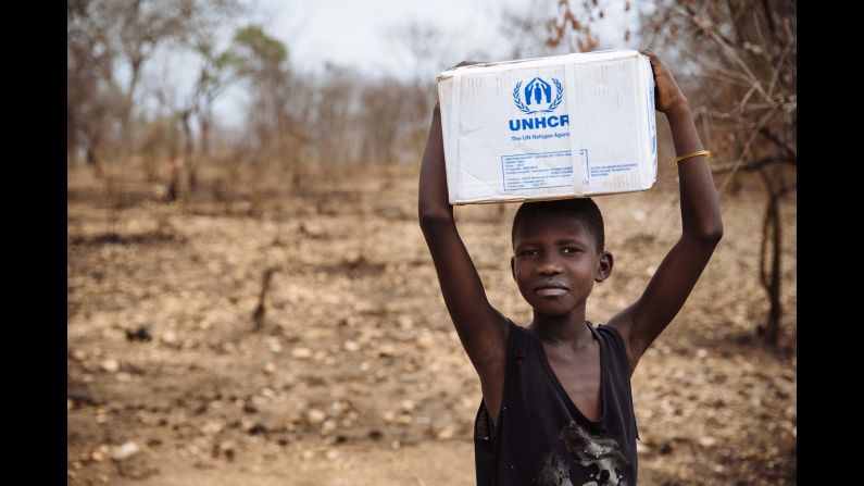 A South Sudanese refugee carrying a box of kitchen utensils, part of the Core Relief Items refugees are given at the recently established Imvepi settlement, Arua District, Northern Region, Uganda. 