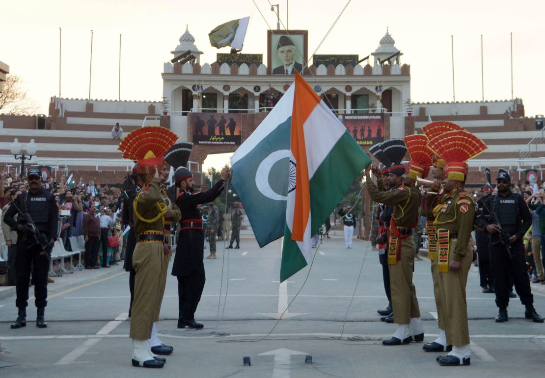 Pakistani Rangers and Indian Border Security Force personnel fold their respective national flags as they perform during the daily beating of the retreat ceremony on the India-Pakistan Border at Wagah on February 20, 2017. 
