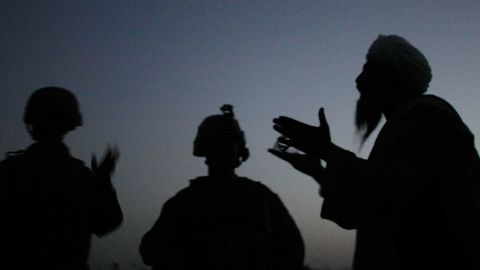 An Afghan man talks to a US Marine through an interpreter in Mian Poshteh, Afghanistan, July 14, 2009.