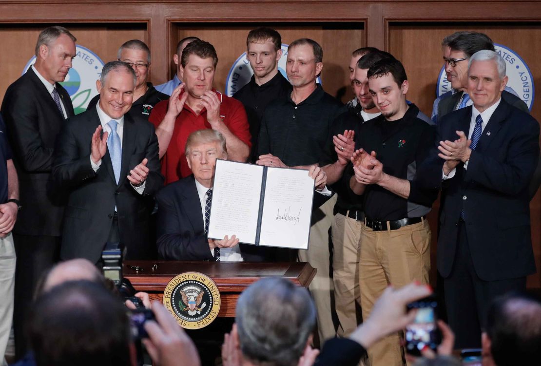 President Donald Trump holds up the signed executive order "Promoting Energy Independence and Economic Growth" Tuesday, March 28, 2017, at EPA headquarters in Washington. (AP Photo/Pablo Martinez Monsivais)