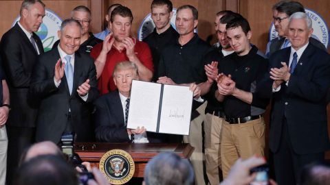 President Donald Trump holds up the signed executive order "Promoting Energy Independence and Economic Growth" Tuesday, March 28, 2017, at EPA headquarters in Washington. (AP Photo/Pablo Martinez Monsivais)