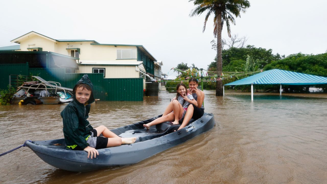 Three children paddle in a kayak after flood waters entered their backyard on March 30, in Murwillumbah, Australia.