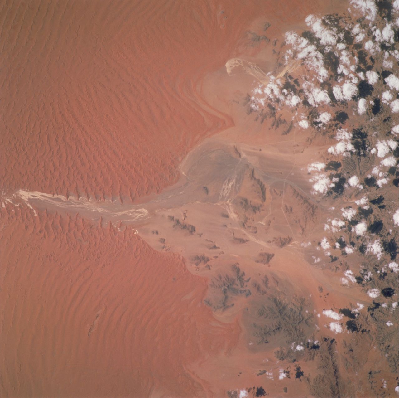 Winds moving north caused the deep red dunes that can be seen in this image of the Sossus Vlei clay pan in Namibia, taken by an astronaut in 2001.