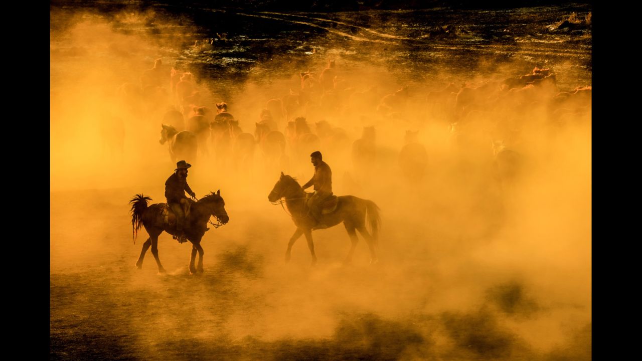 Men ride with a herd of horses Tuesday, March 28, at the foothills of Mount Erciyes in Kayseri, Turkey.