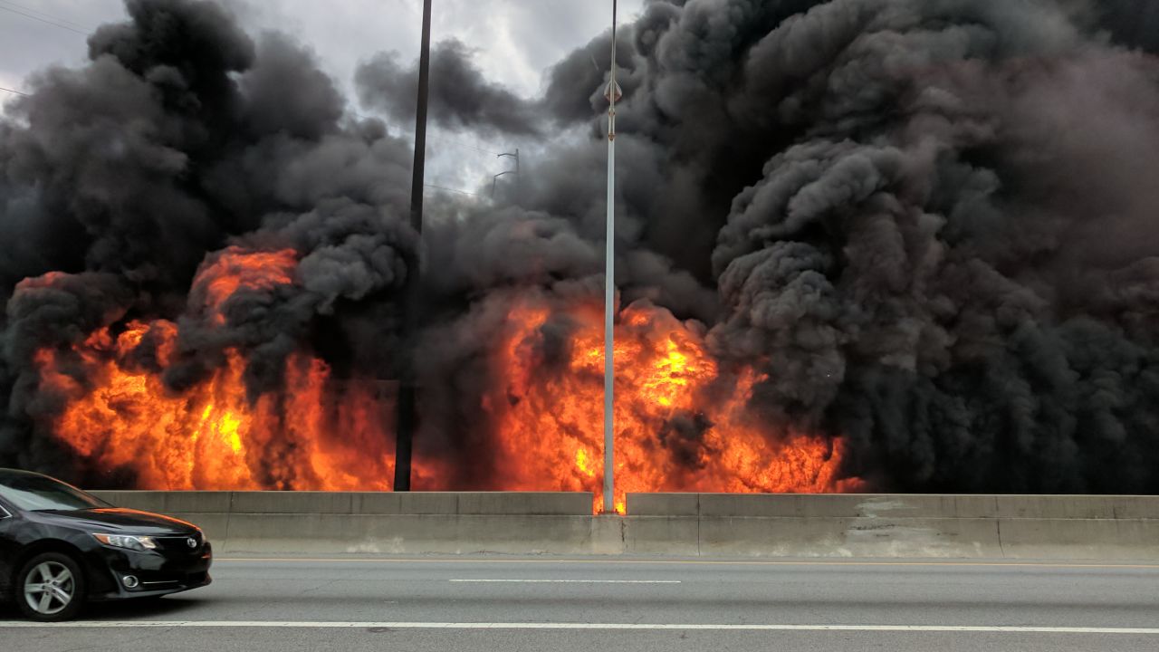 Flames rise Thursday evening along an elevated stretch of Interstate 85 north of downtown Atlanta.