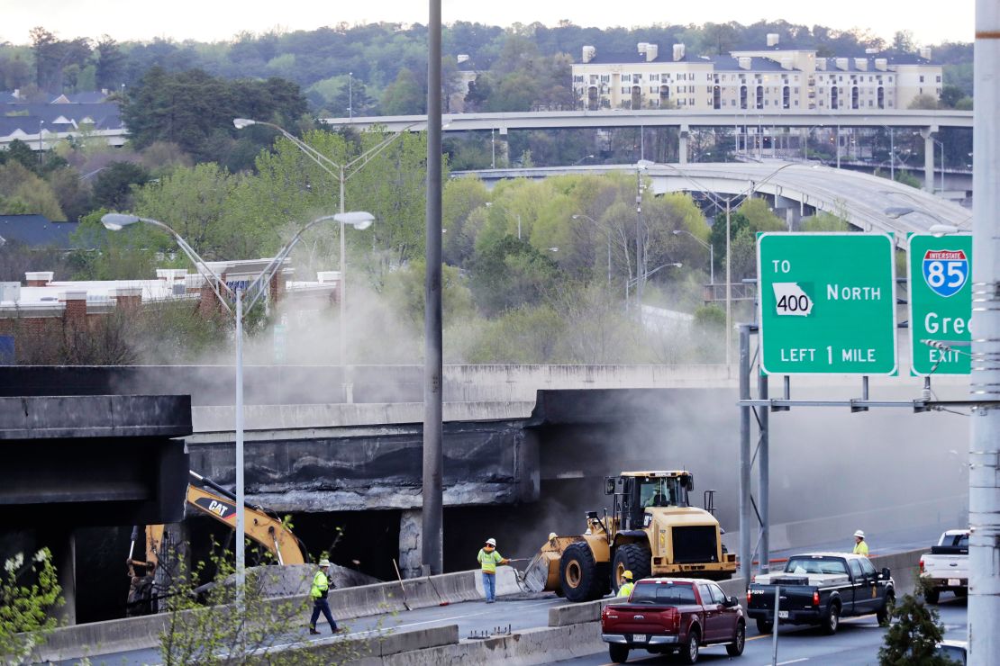 Crews work Friday on a section of an Interstate 85 overpass that collapsed during a masive fire.