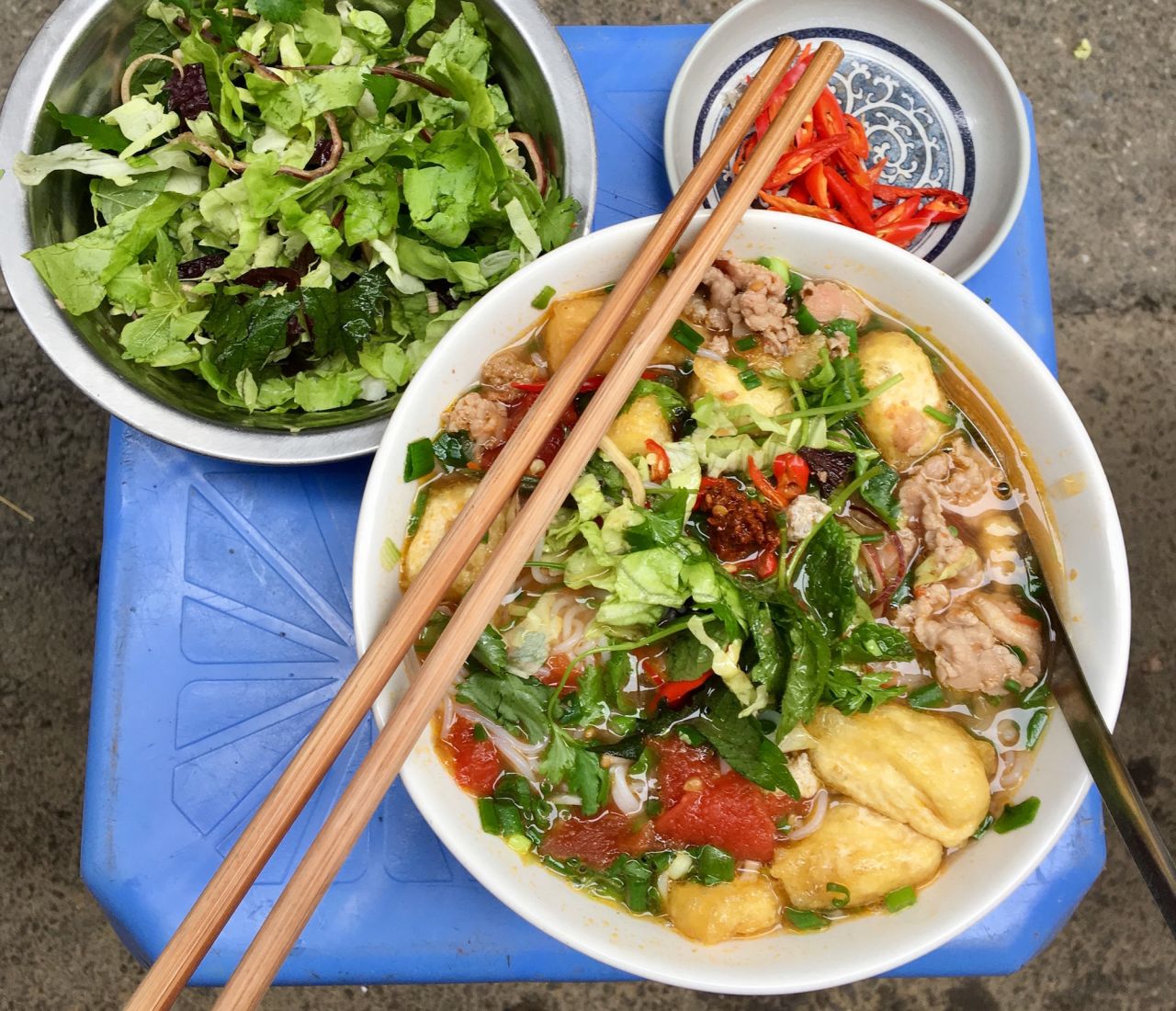 The first thing you'll notice about Bún riêu -- a meat or seafood vermicelli soup -- is its red hue.
