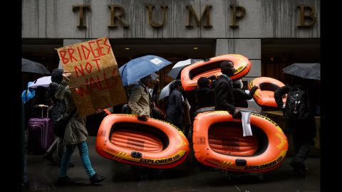 People carry inflatable rafts in front of New York's Trump Tower as they protest the President's refugee policies on Tuesday, March 28.