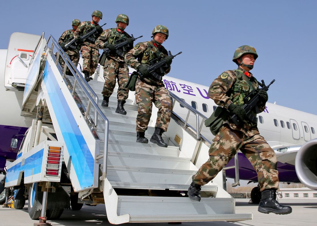 Chinese military police get off a plane to attend an anti-terrorist oath-taking rally in Xinjiang, on February 27.