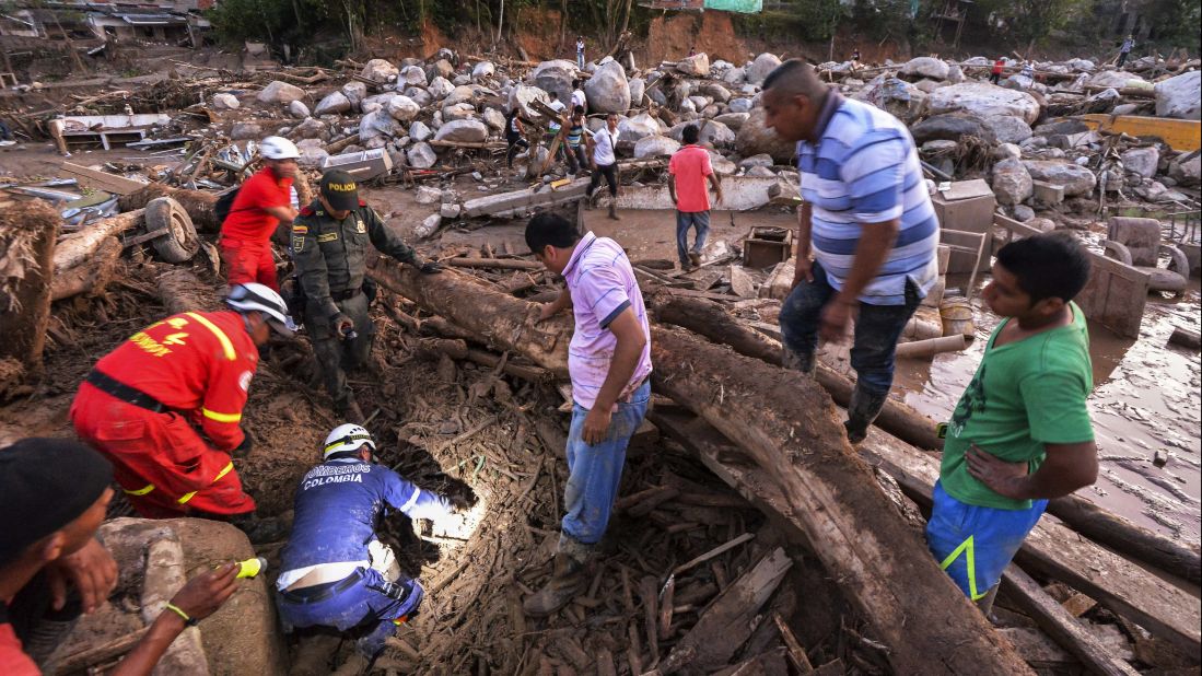 Rescuers search for people among the debris left by mudslides.