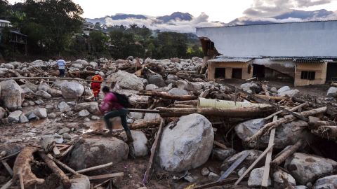 People walk through heaps of rubble left by the mudslides in Mocoa.