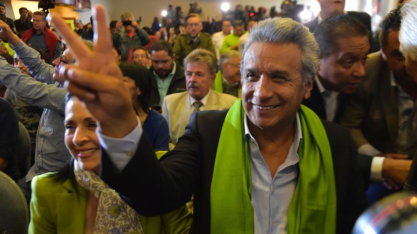 The Ecuadorean presidential candidate of the ruling Alianza PAIS party, Lenin Moreno, gives the "V for victory" sign next to his wife Rocio Gonzalez (L) as they listen with supporters to the first results of the runoff election, in Quito on April 2, 2017. / AFP PHOTO / RODRIGO BUENDIA        (Photo credit should read RODRIGO BUENDIA/AFP/Getty Images)