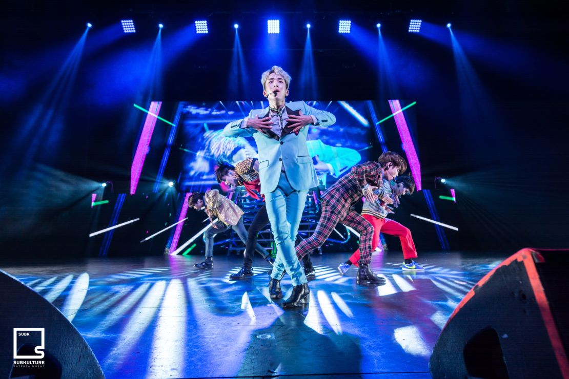 Key sings in the front of the rest of the SHINee band in Dallas.