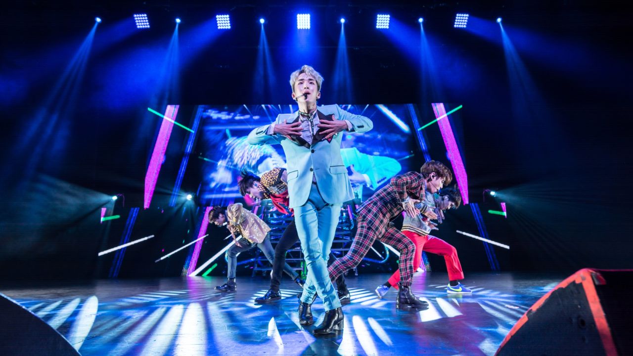 Key sings in the front of the rest of the SHINee band in Dallas.