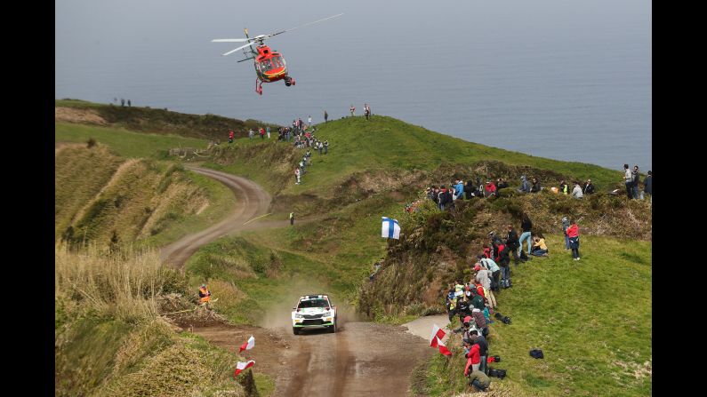 The rally car of Marijan Griebel and Stefan Kopczyk speeds past race fans in Ponta Delgada, Portugal, on Friday, March 31.