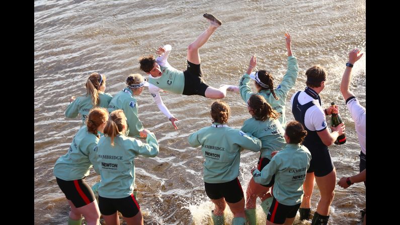 The women's crew from Cambridge celebrates its win in the annual University Boat Race by throwing Matthew Holland into London's River Thames on Sunday, April 2.