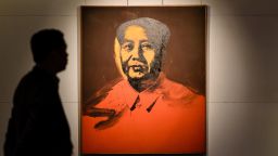 A man walks past Mao by US artist Andy Warhol, 1973, an acrylic and silkscreen ink on canvas, during a pre-auction preview by Sotheby's in Hong Kong on March 17, 2017.
An Andy Warhol portrait of former Chinese leader Mao Zedong will be auctioned in Hong Kong in a landmark sale that could fetch 15 million USD -- but mainland buyers may be wary of putting in a bid. The classic 1973 screen print by the legendary US pop artist will go under the hammer at Sotheby's next month with the highest estimate the auction house has ever seen for a painting in Asia. It comes as demand grows in the region for a wider variety of works, driven by appetite in China. The auction house describes the event as the first "significant" sale of Western contemporary art in Hong Kong. / AFP PHOTO / Anthony WALLACE / RESTRICTED TO EDITORIAL USE - MANDATORY MENTION OF THE ARTIST UPON PUBLICATION - TO ILLUSTRATE THE EVENT AS SPECIFIED IN THE CAPTION        (Photo credit should read ANTHONY WALLACE/AFP/Getty Images)