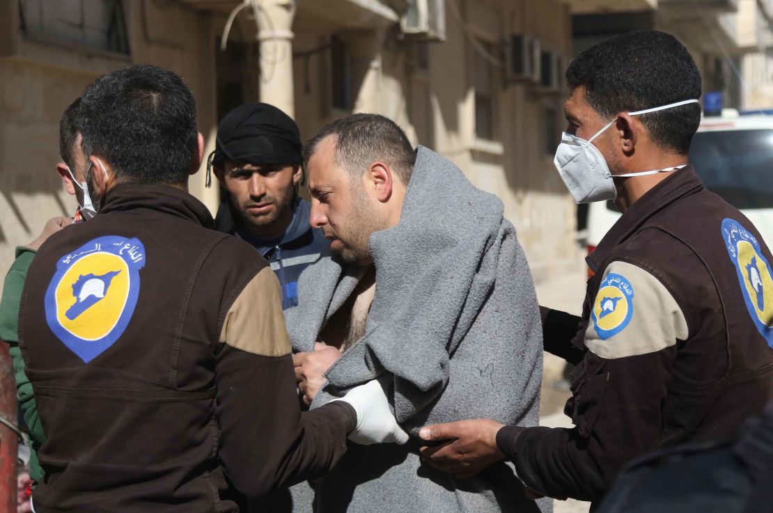 A man is aided by civil defense workers in Idlib on Tuesday.