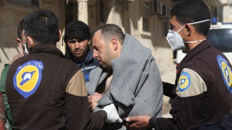 A man is aided by civil defense workers in Idlib on Tuesday.