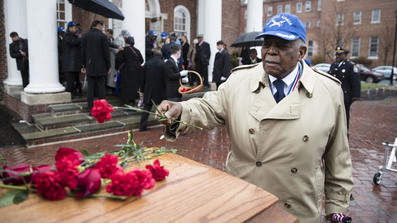 Eugene J. Richardson Jr. places a flower on the casket of his former comrade, John L. Harrison Jr., at a funeral in Philadelphia on Friday, March 31. Both were <a href="http://www.cnn.com/2015/01/12/us/feat-tuskegee-airmen-obit/" target="_blank">Tuskegee Airmen</a> who served during World War II.