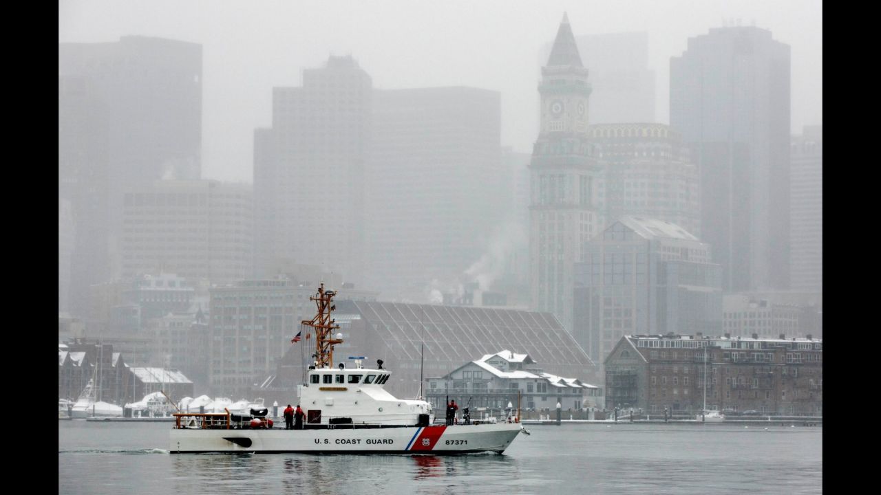 A US Coast Guard boat patrols Boston Harbor as snow falls on Friday, March 10.