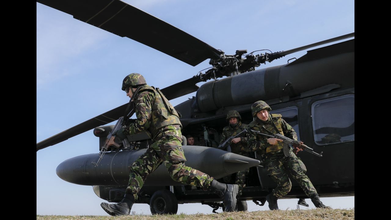Romanian troops run out of an US Army helicopter during a joint exercise in eastern Romania on Wednesday, March 8.