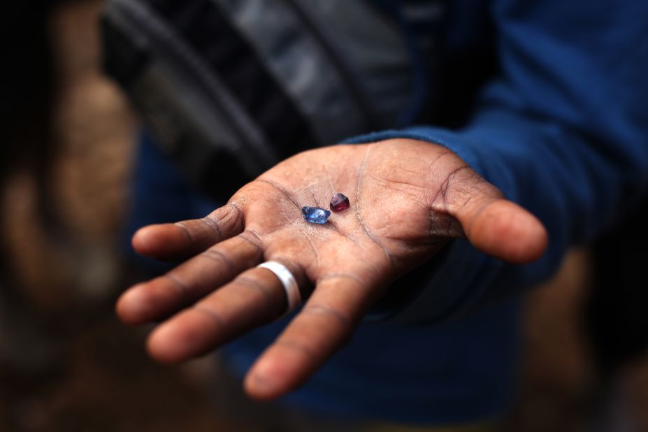 A man shows a sapphire and a ruby at the sapphire mine in Ankeniheny-Zahamena. Stones have been recovered that have been mistaken for Kashmiri sapphires - regarded as the finest in the world. 