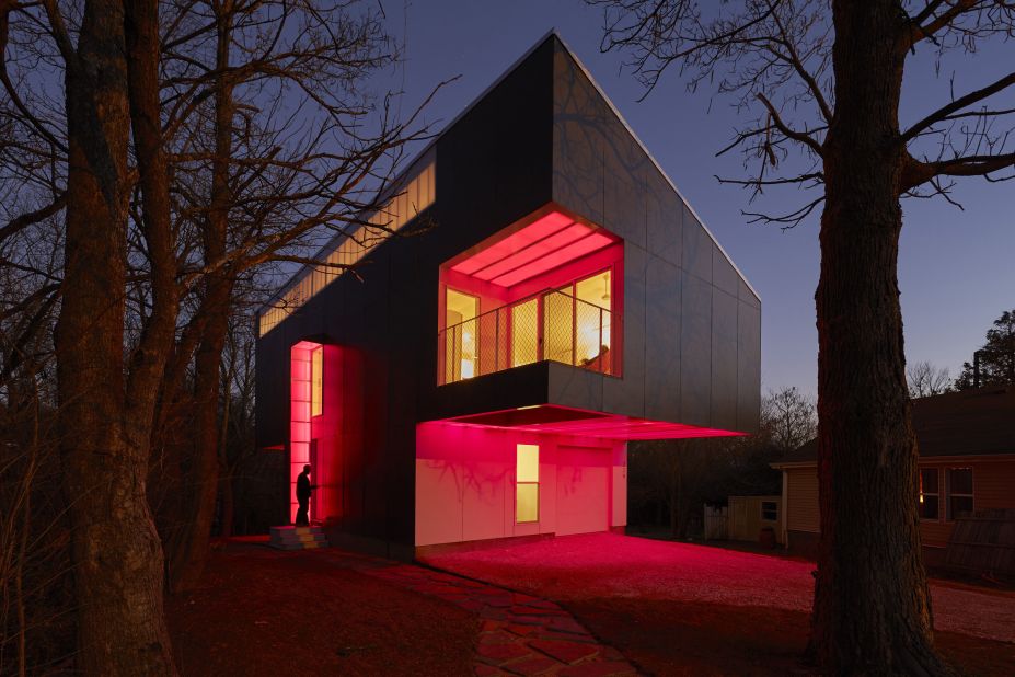 The house, surrounded by nature, projects colorful LED lights that the architect and his family choose at night.