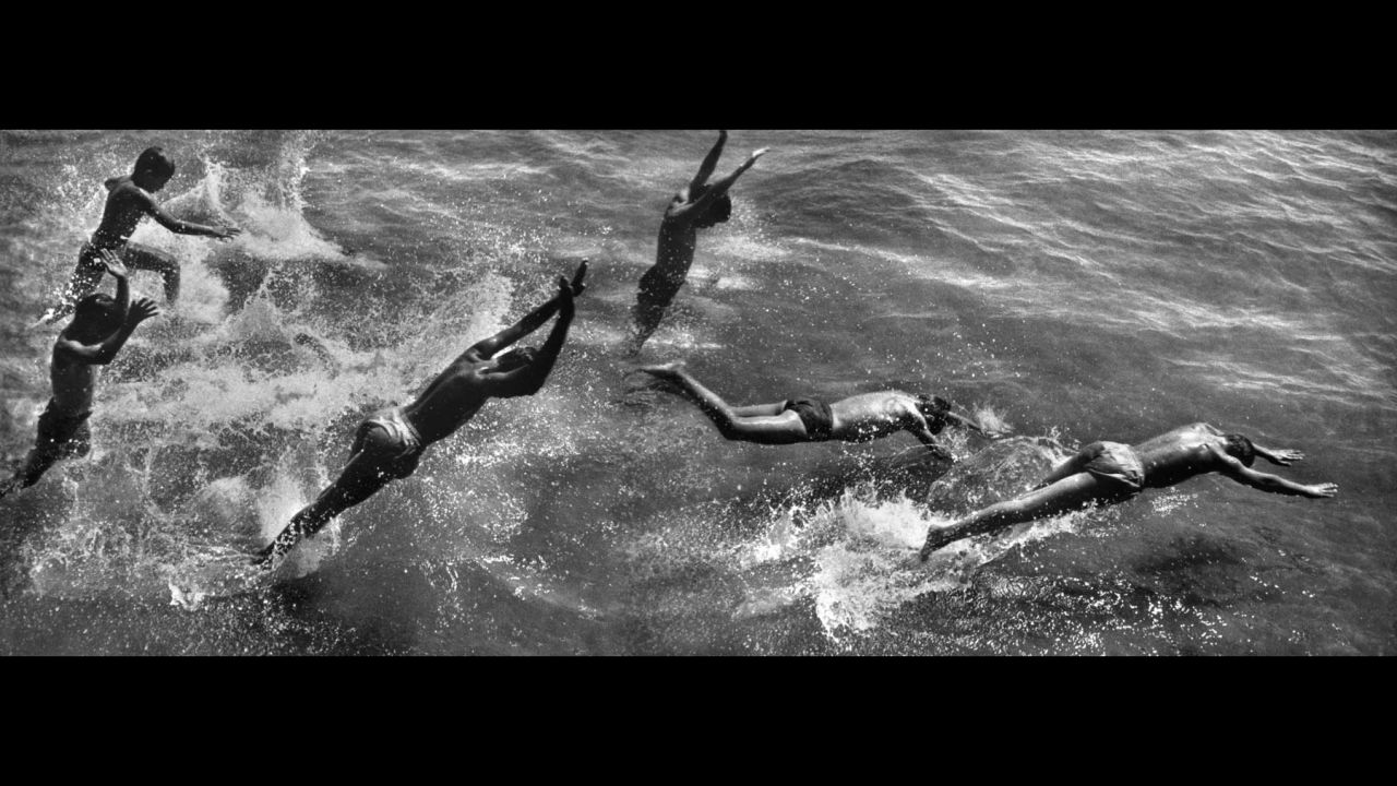 Boys dive into the ocean in this Coney Island montage, which was created in the darkroom from three negatives.