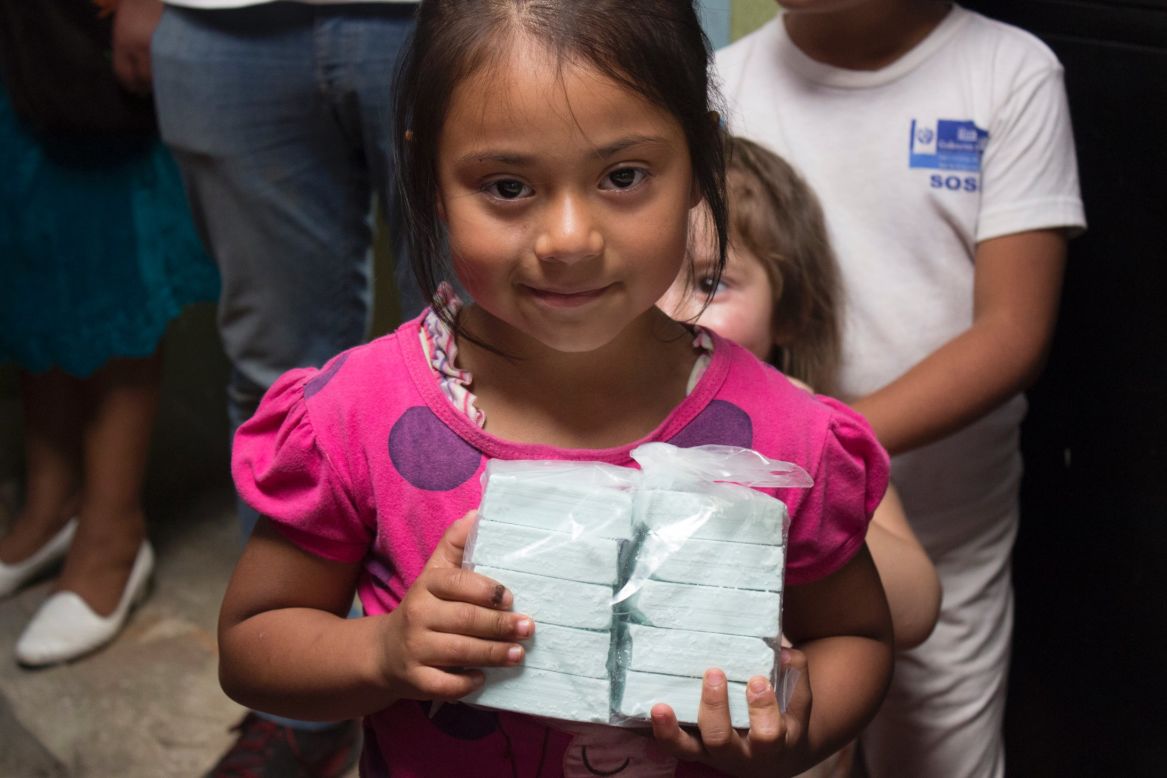 A Guatemalan child holds bars of soap Clean the World distributed in 2015.
