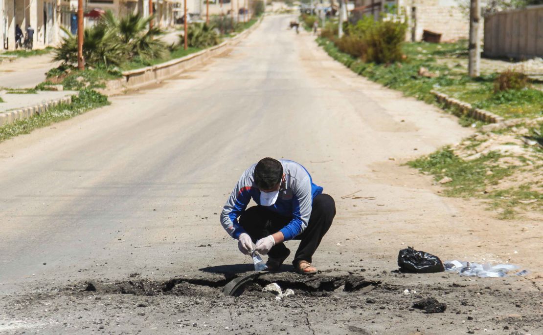 A Syrian man collects samples from the site of a suspected toxic gas attack in Khan Sheikhoun on April 5.