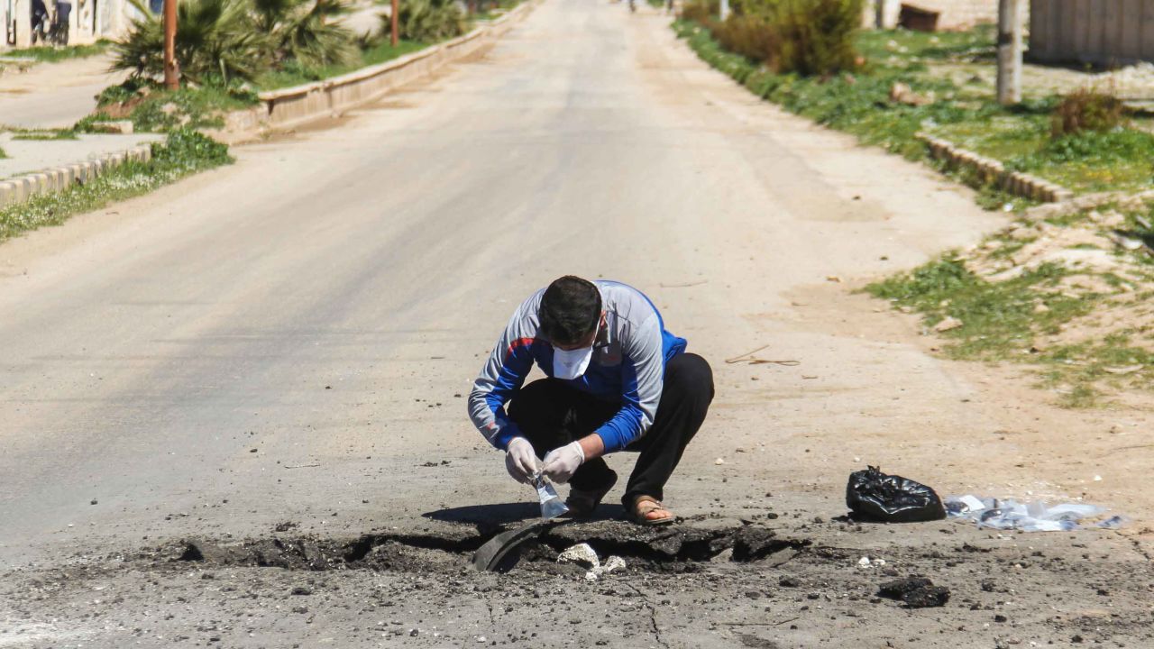 A Syrian man collects samples from the site of a suspected toxic gas attack in Khan Sheikhoun on April 5.