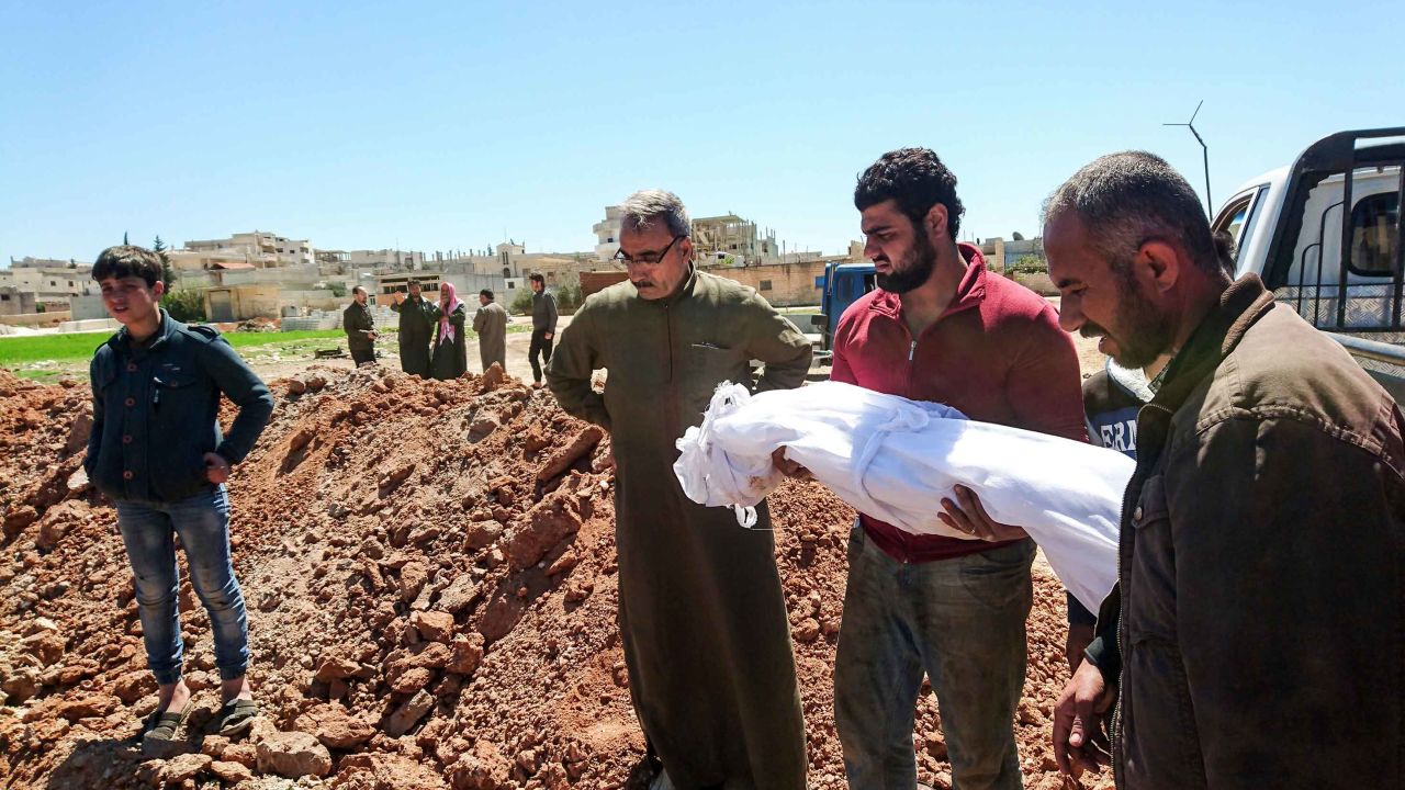 Syrians bury the bodies of victims of a a suspected toxic gas attack in Khan Sheikhun, a nearby rebel-held town in Syrias northwestern Idlib province, on April 5, 2017.
International outrage is mounting over a suspected chemical attack that killed scores of civilians in Khan Sheikhun on April 4, 2017. 
Warplanes had carried out a suspected toxic gas attack that killed dozens people including several children, a monitoring group said. 
The Syrian Observatory for Human Rights said those killed in the town of Khan Sheikhun, in Idlib province, had died from the effects of the gas, adding that dozens more suffered respiratory problems and other symptoms. / AFP PHOTO / FADI AL-HALABI        (Photo credit should read FADI AL-HALABI/AFP/Getty Images)